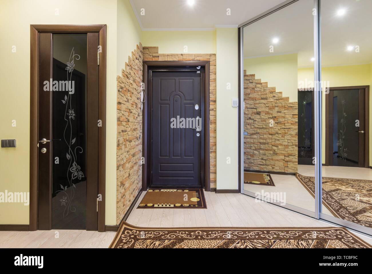 Spacious entrance hall in the apartment with built-in wardrobe and huge  mirrors Stock Photo - Alamy