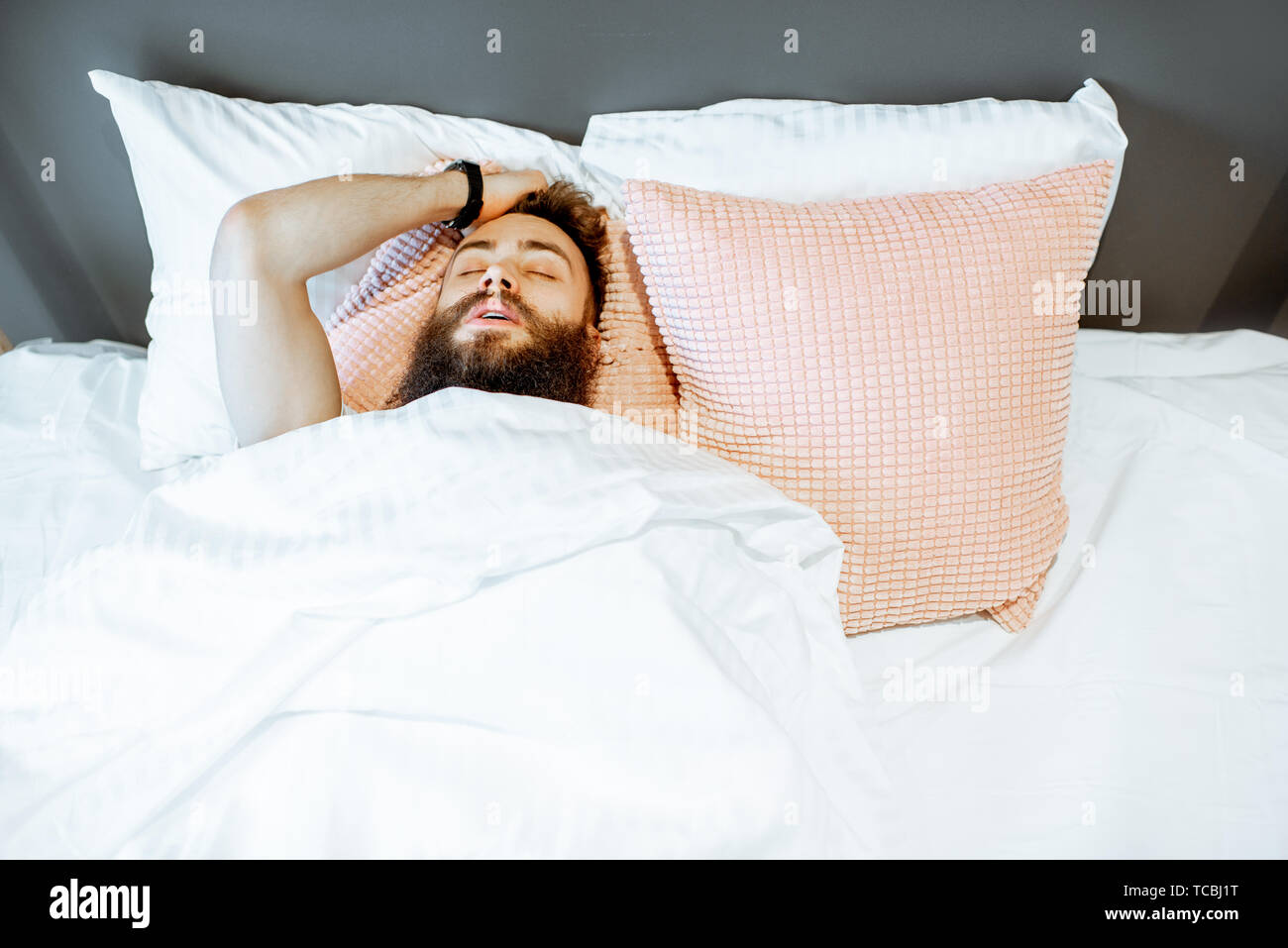 Man feeling stressed lying on the bed, suffering from insomnia or nightmares Stock Photo