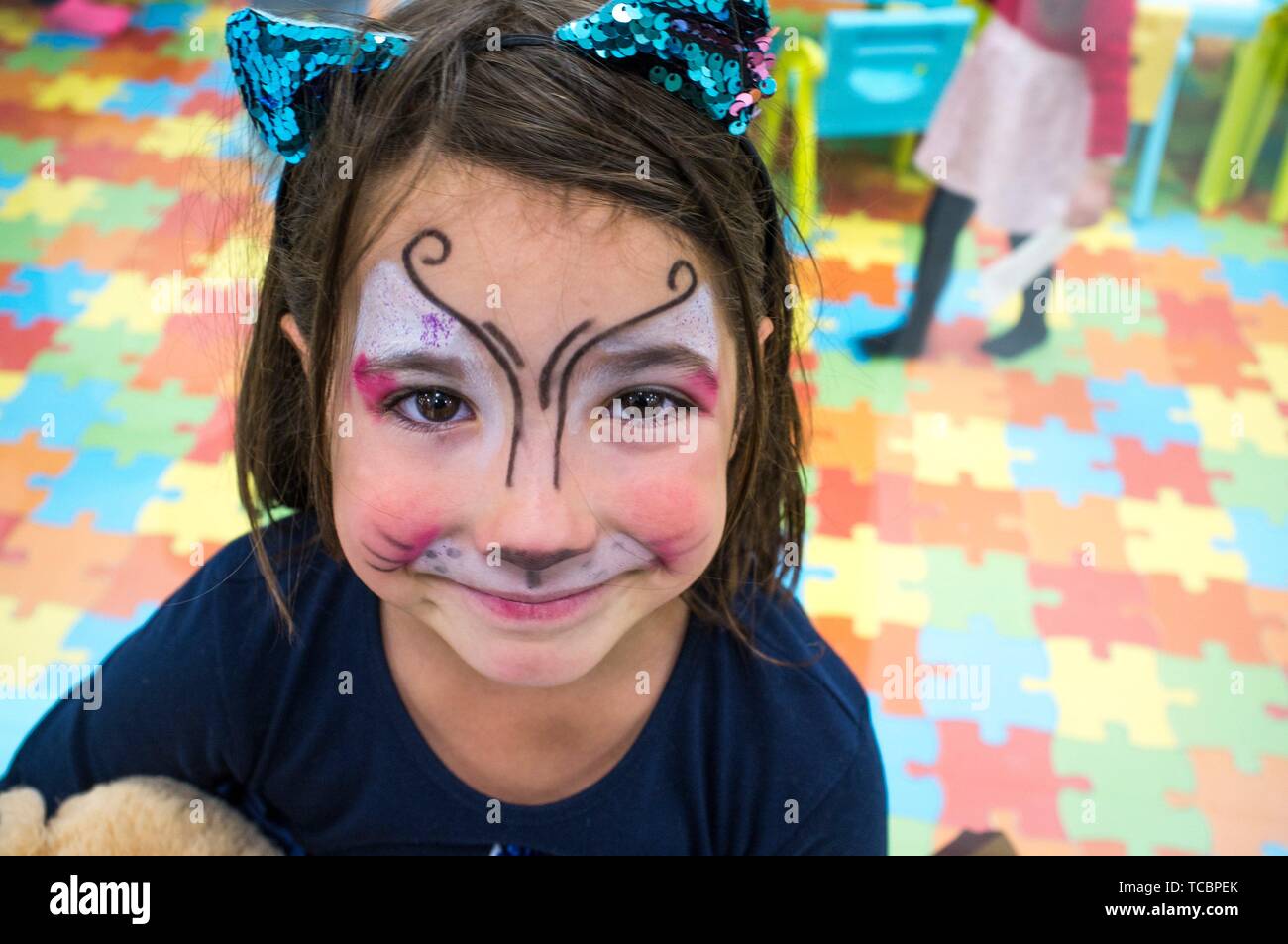 Child girl posing face painted during at Children Playroom. High angle shot. Stock Photo