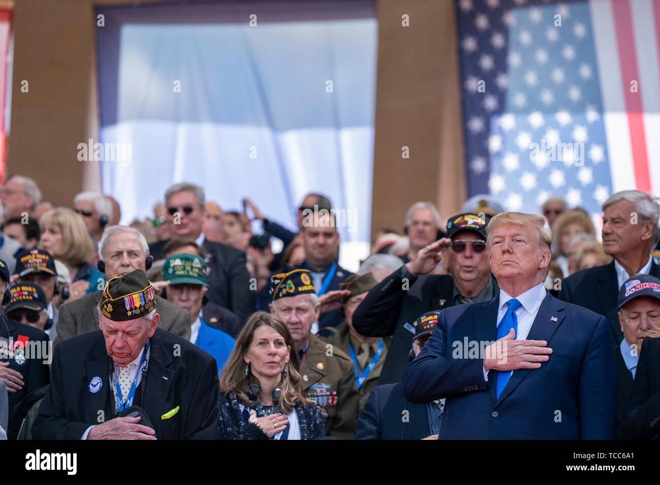 Colleville Sur Mer, France. 06th June, 2019. U.S. President Donald Trump stands for the national anthems during the commemoration ceremony marking the 75th D-Day Anniversary at the Normandy American Cemetery and Memorial June 6, 2019 in Colleville-sur-Mer, France. Thousands have converged on Normandy to commemorate the 75th anniversary of Operation Overlord, the WWII Allied invasion commonly known as D-Day. Credit: Planetpix/Alamy Live News Stock Photo