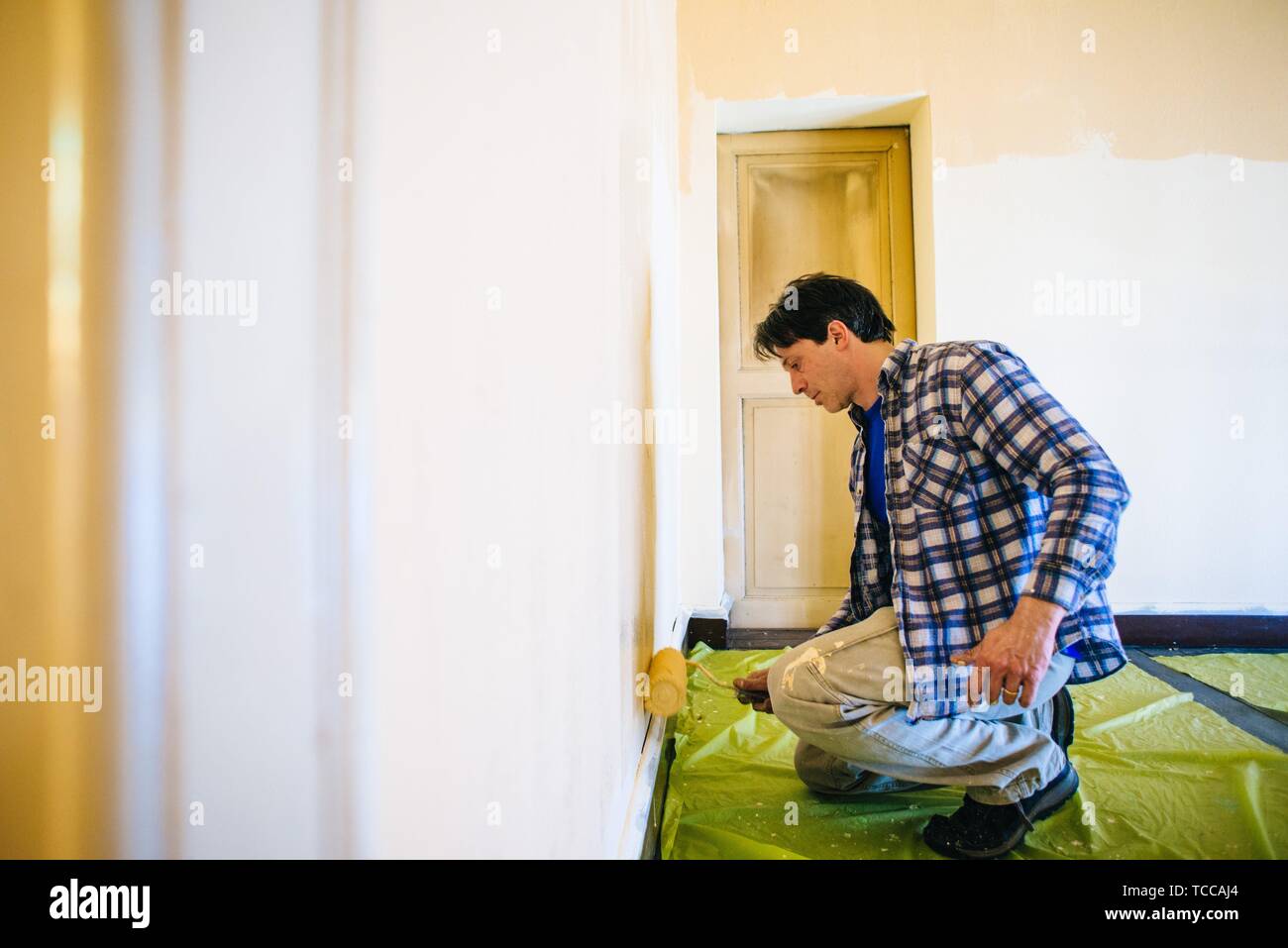husband father of forty years, paints house wall man painting wall of