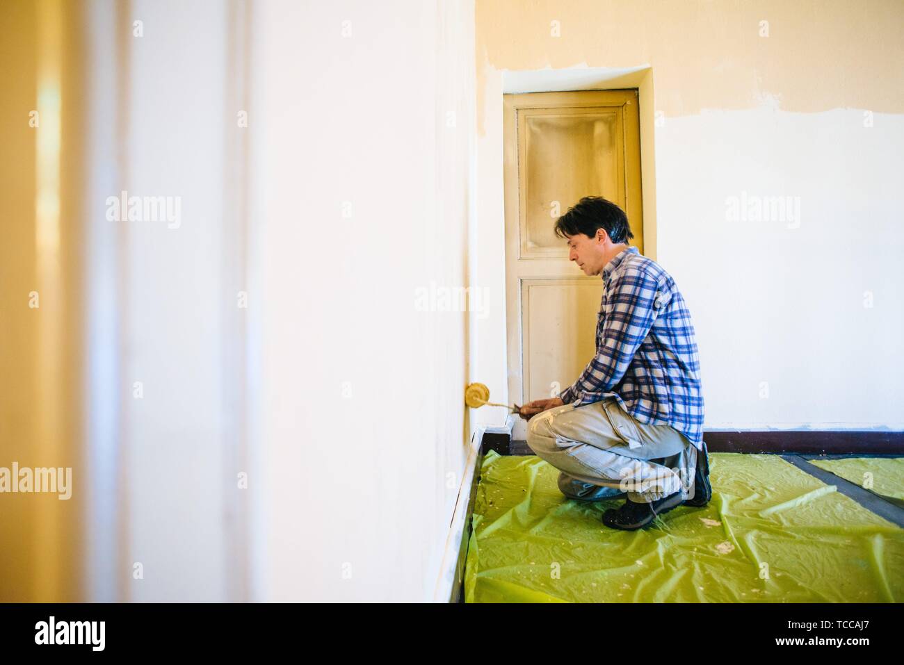 husband father of forty years, paints house wall man painting wall of