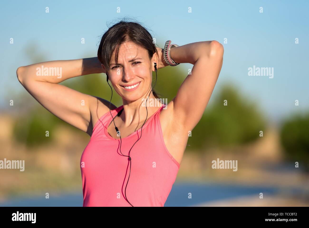 Attractive young woman in sports clothing smiling. Fitness model. Stock Photo