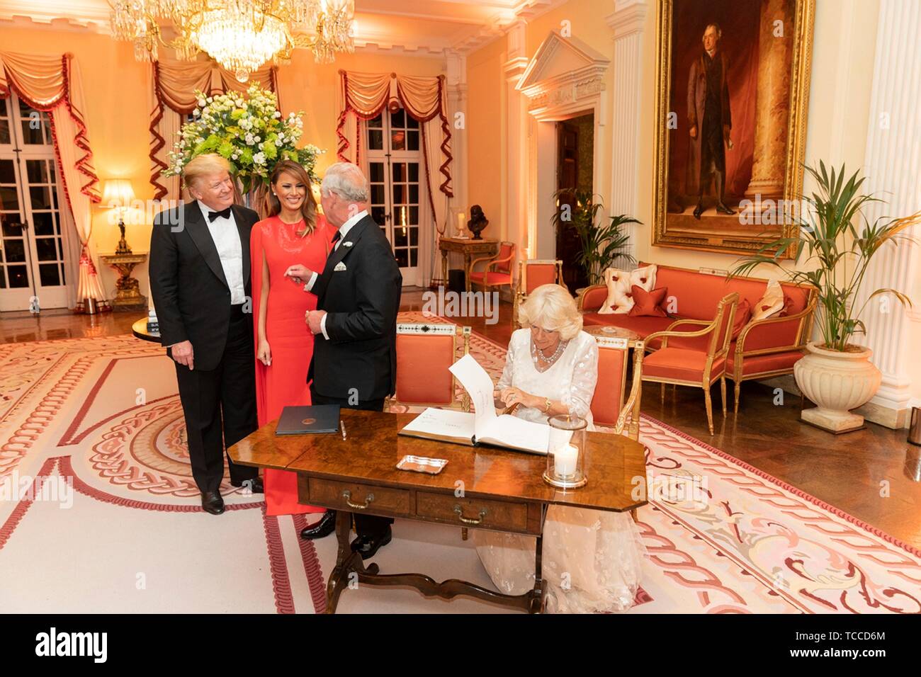 U.S President Donald Trump and First Lady Melania Trump look on as Prince  of Wales and the Duchess of Cornwall sign the guestbook during a gala at  Winfield House hosted by the