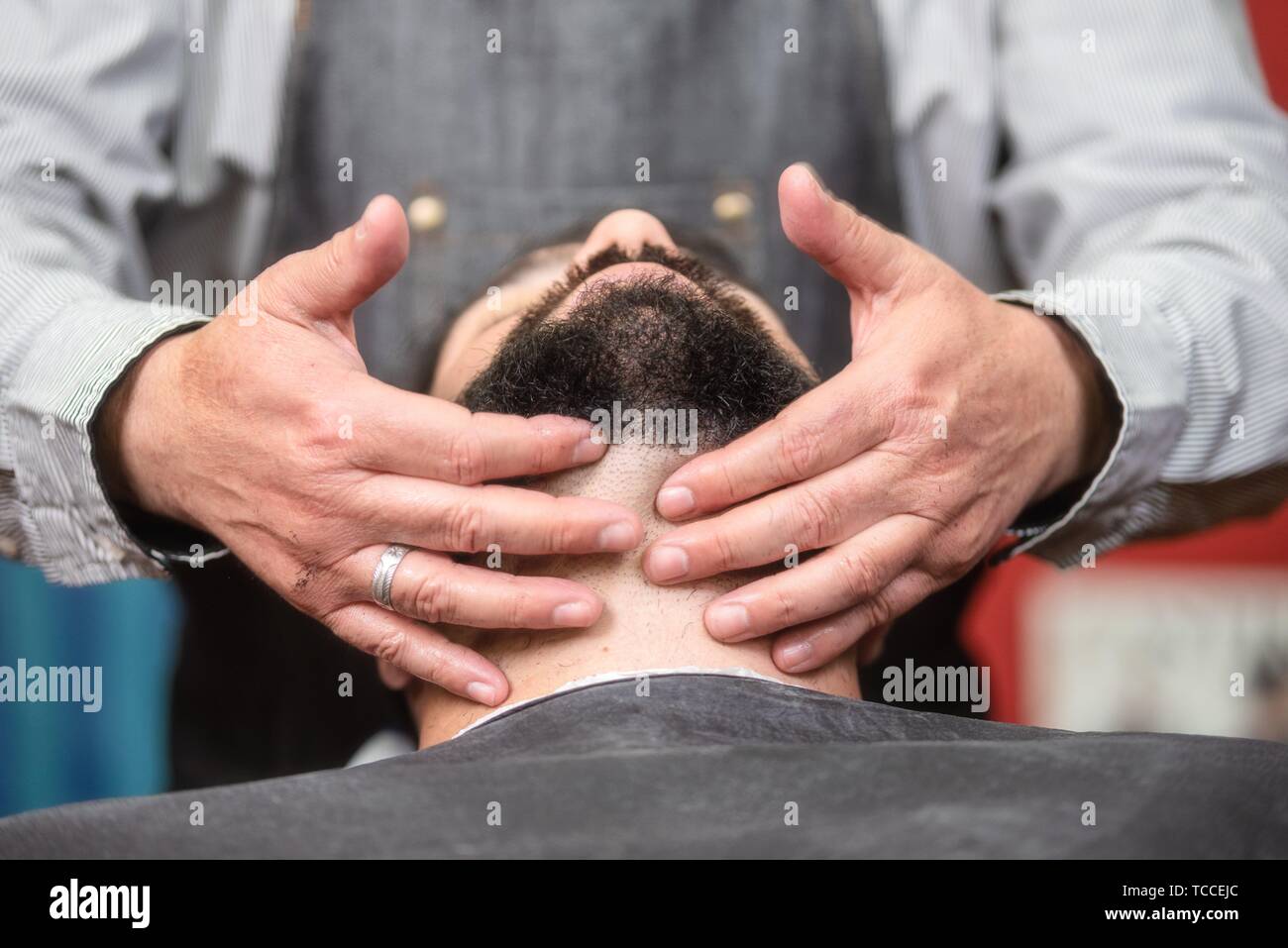 Hair stylist applying after shaving lotion at barber shop. Stock Photo