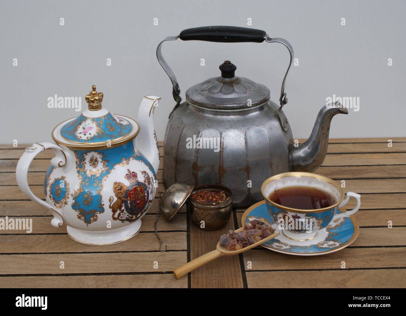 Nostalgic water kettle with english teapot, english tea cup, filled tea  infuser and candy Stock Photo - Alamy