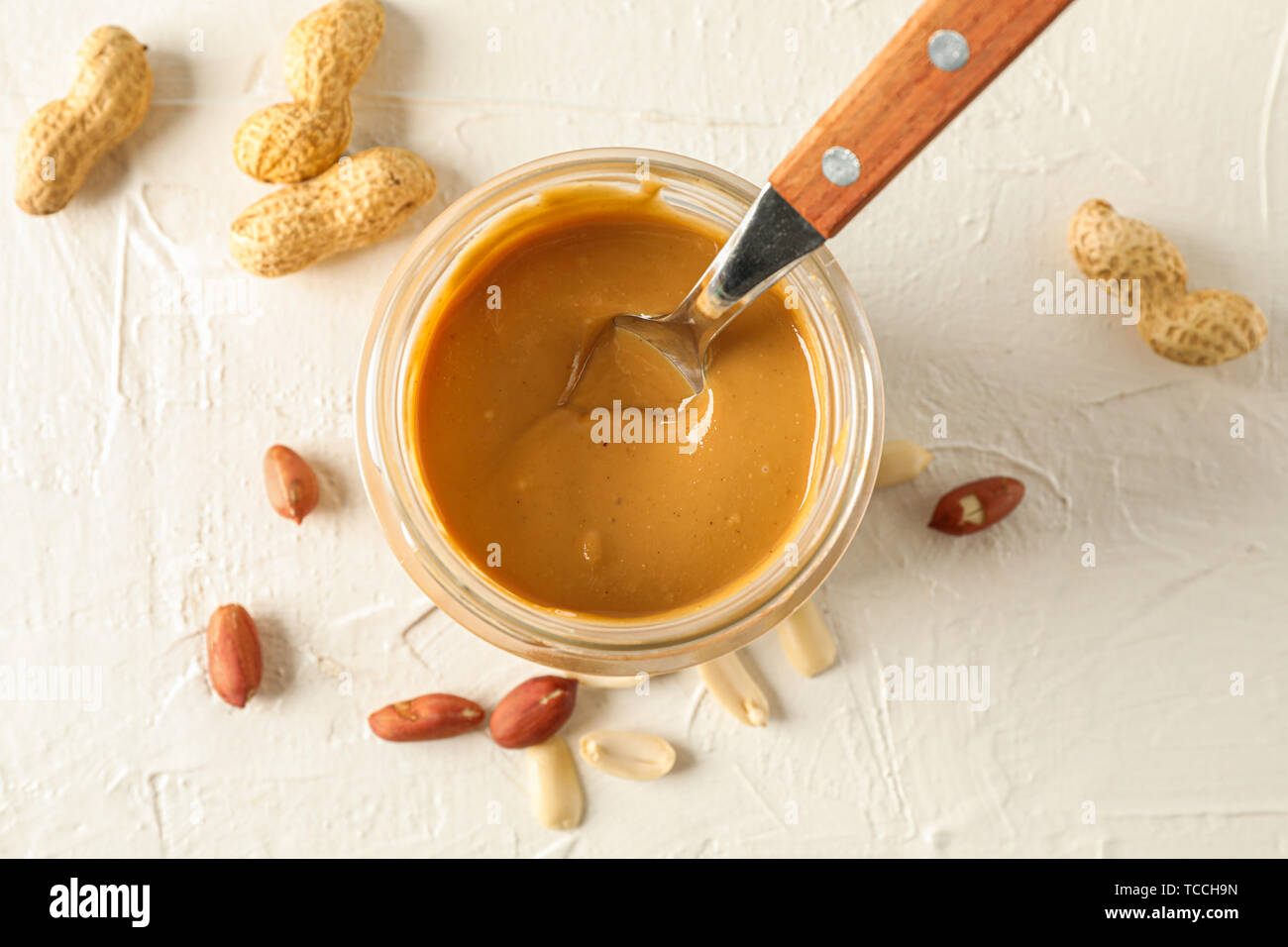 https://c8.alamy.com/comp/TCCH9N/glass-jar-with-creamy-peanut-butter-and-spoon-and-peanut-on-white-background-space-for-text-and-top-view-TCCH9N.jpg