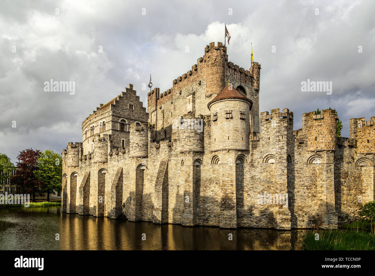 Fortified walls and towers of Gravensteen medieval castle with moat in the foreground, Ghent East Flanders, Belgium Stock Photo