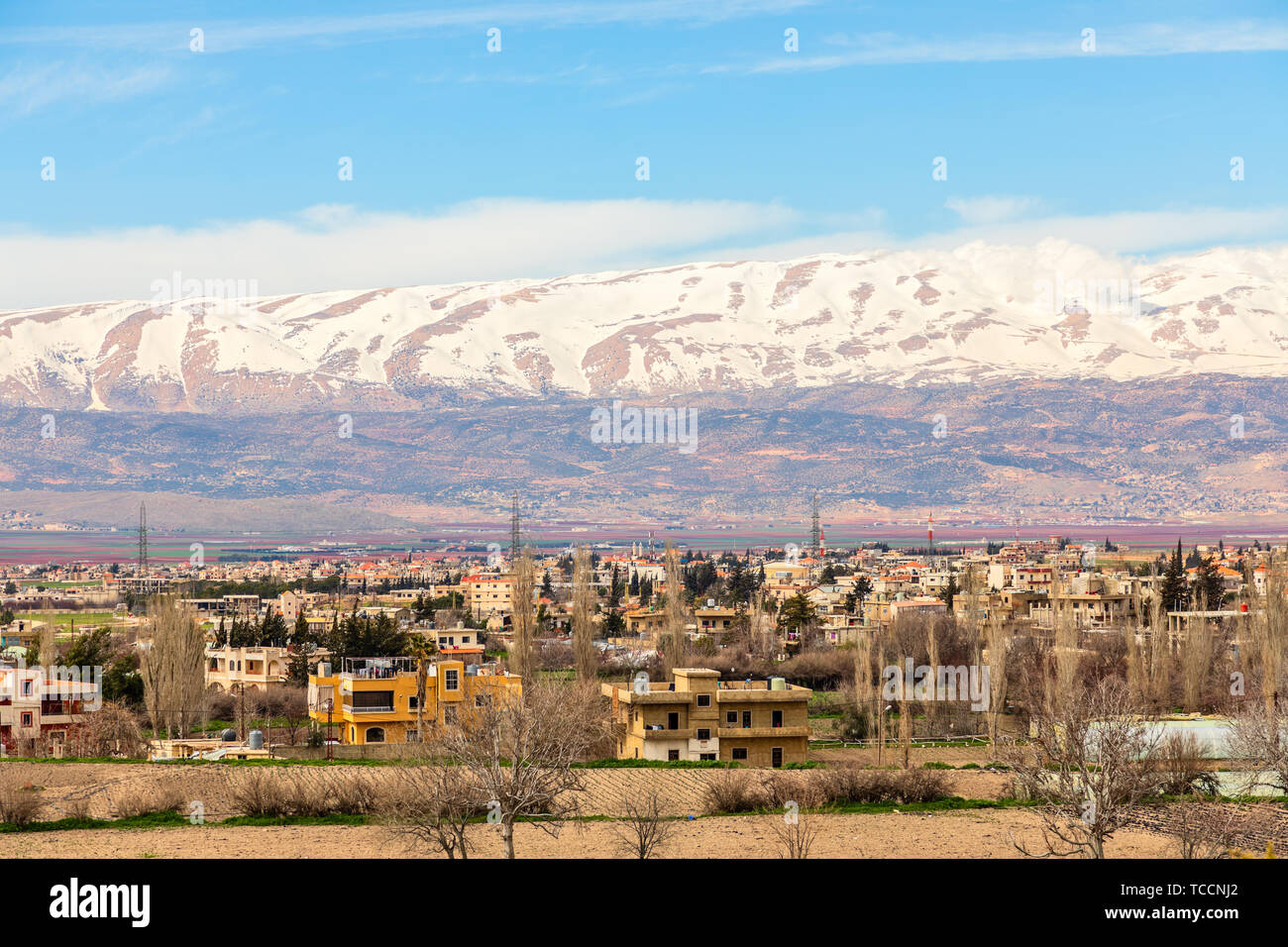 Lebanese houses in Beqaa Valley with snow cap mountains in the background, Baalbeck, Lebanon Stock Photo