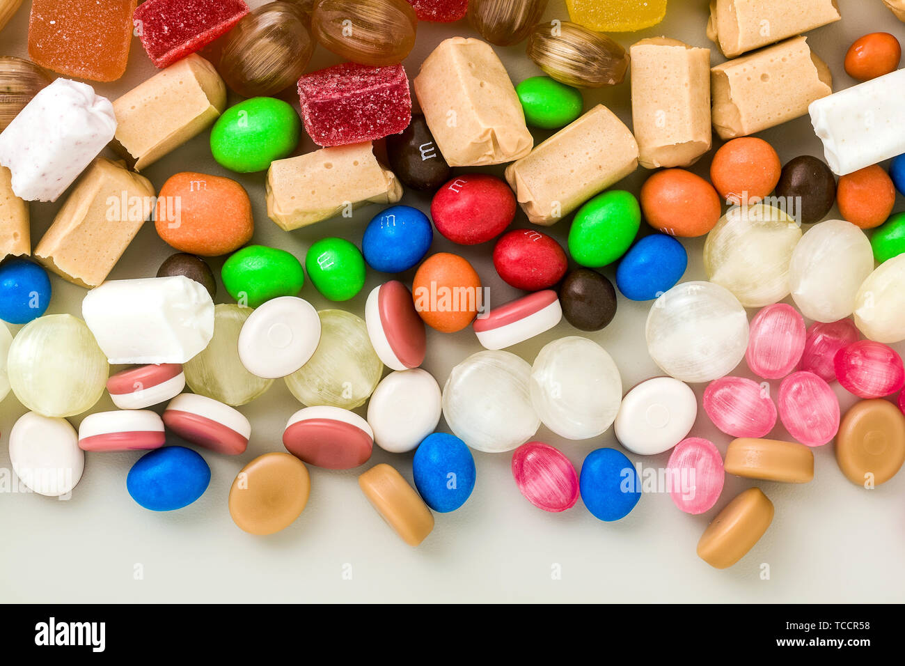 multicolored caramel candies scattered on the table background. sugar products. colored sweets Stock Photo