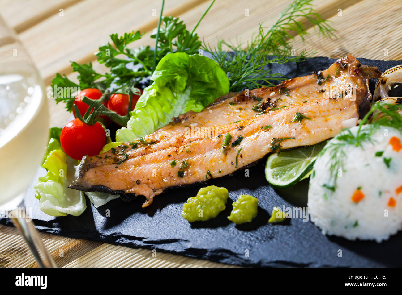 Fish dish delicious fried trout fillet with rice and herbs served on