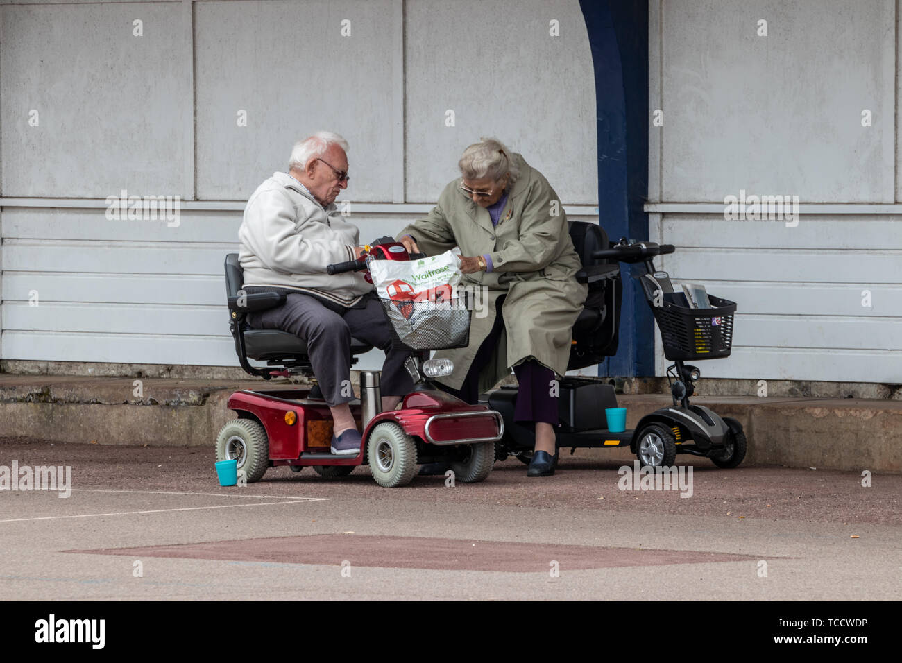 An elderly couple on mobility scooters Stock Photo