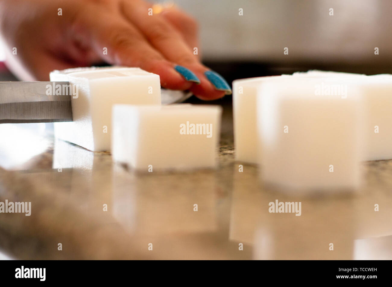 lady cutting cold process soap base into blocks for melting Stock Photo