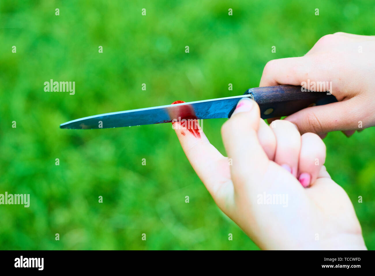 Accident wounded on finger with blood and knife. Child playing with knife. Self injure Stock Photo