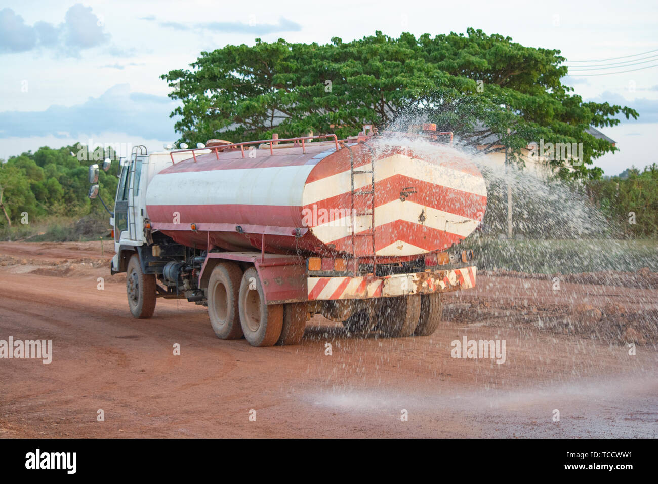 Water truck sprays water for a new road construction site Stock Photo