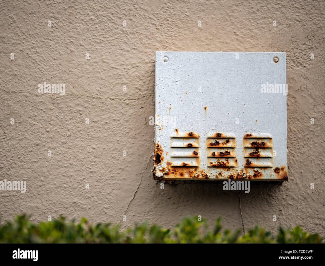Rusty steel box with vents outside of home near bushes Stock Photo - Alamy