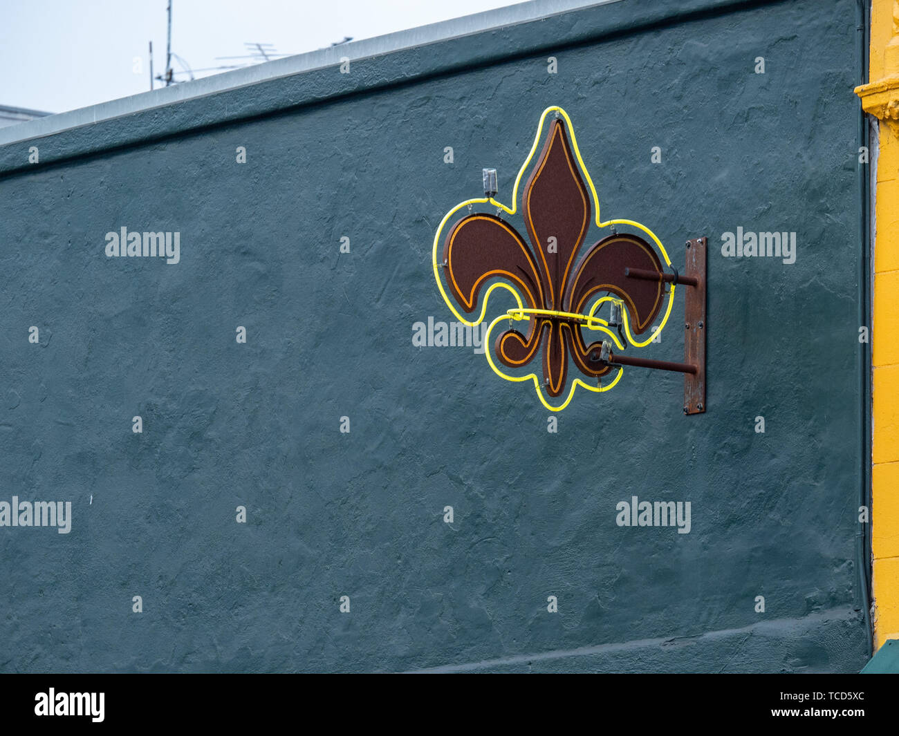 Fleurdelis neon symbol hanging outside of building against blue wall Stock Photo Alamy