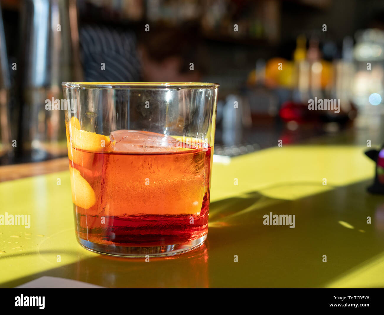 Negroni drink sitting on green bar counter top Stock Photo