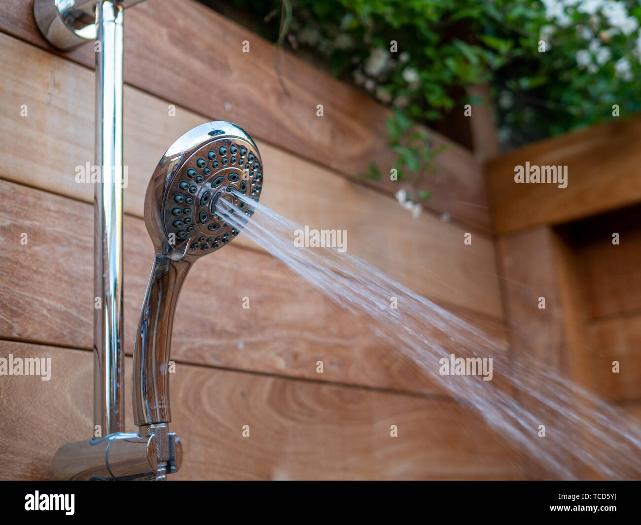 https://c8.alamy.com/comp/TCD5YJ/water-steams-flowing-out-of-handheld-shower-head-in-outdoor-shower-TCD5YJ.jpg