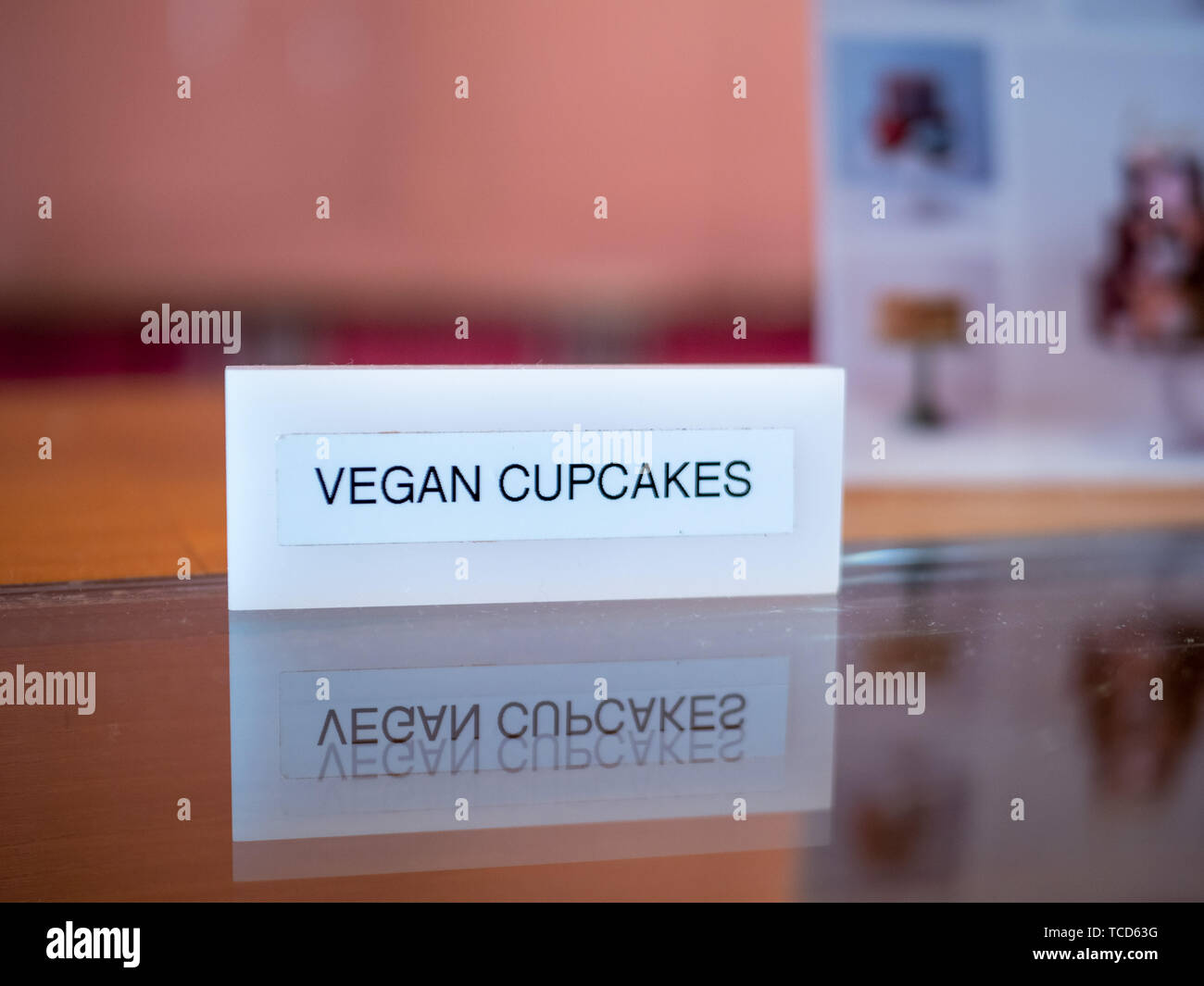 Vegan cupcakes sign sitting on table on counter atvegan bakery Stock Photo