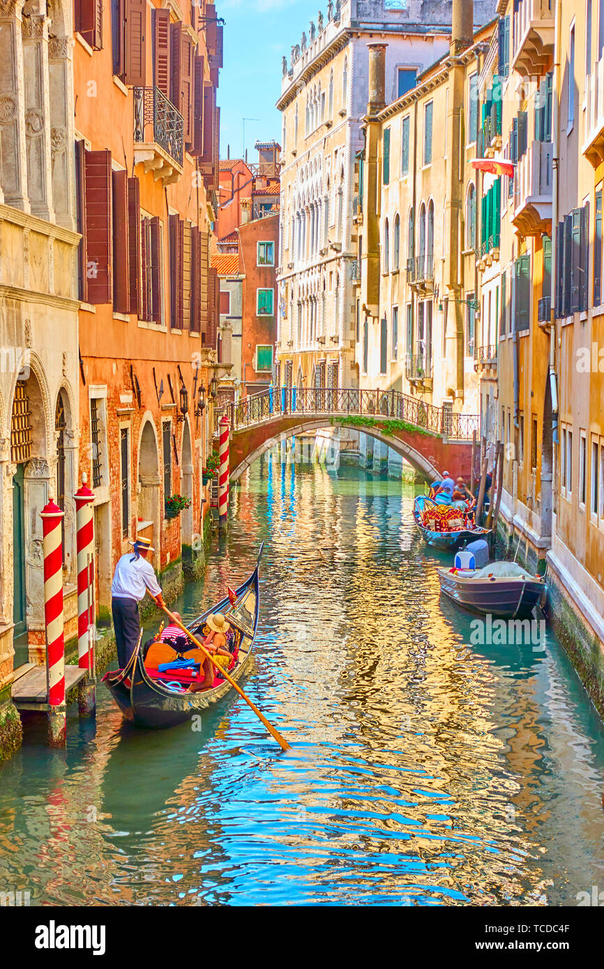 Venetian canal with gondola on sunny summer day, Venice, Italy Stock Photo