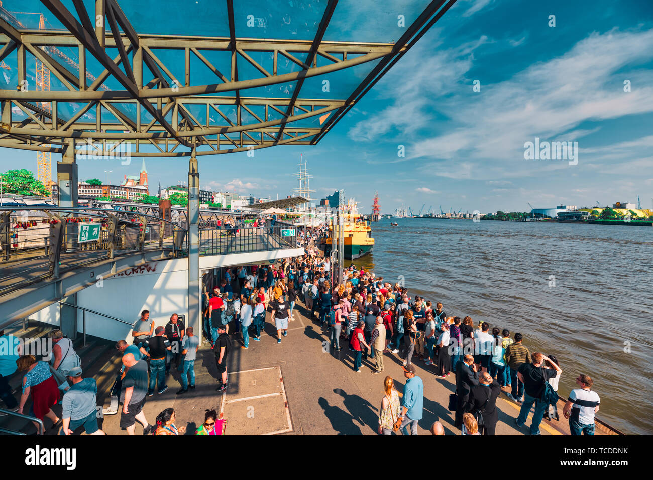 HAMBURG, GERMANY - June 01, 2019: Tourist stroll along the harbor promenade and try to catch one of the tourist boats for the next tour Stock Photo