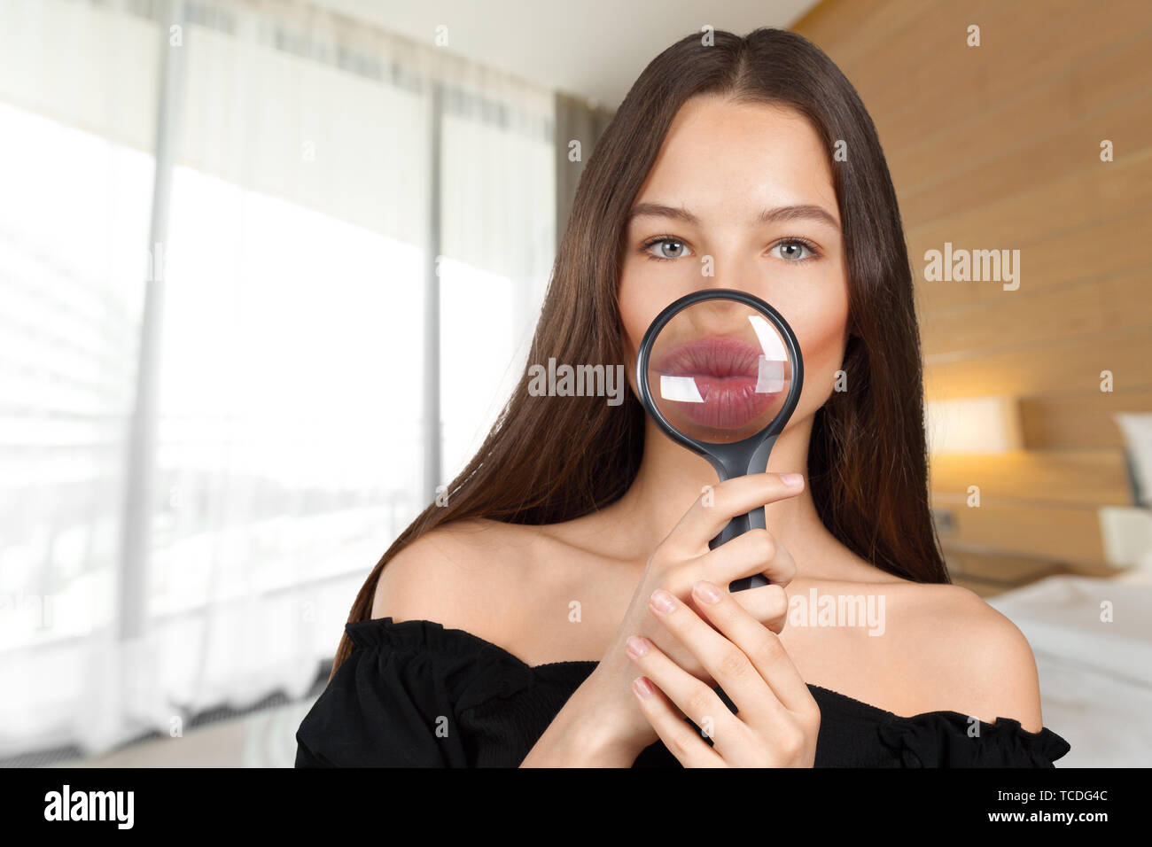 Woman looking through a magnifying glass Stock Photo - Alamy
