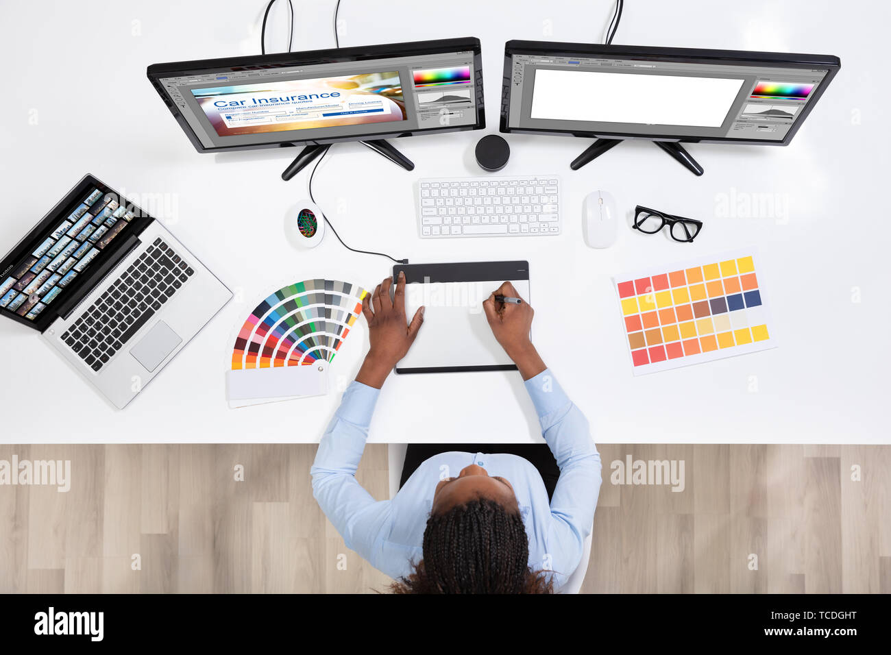 Young Female Designer Editing Photos On Computer In Office Stock Photo