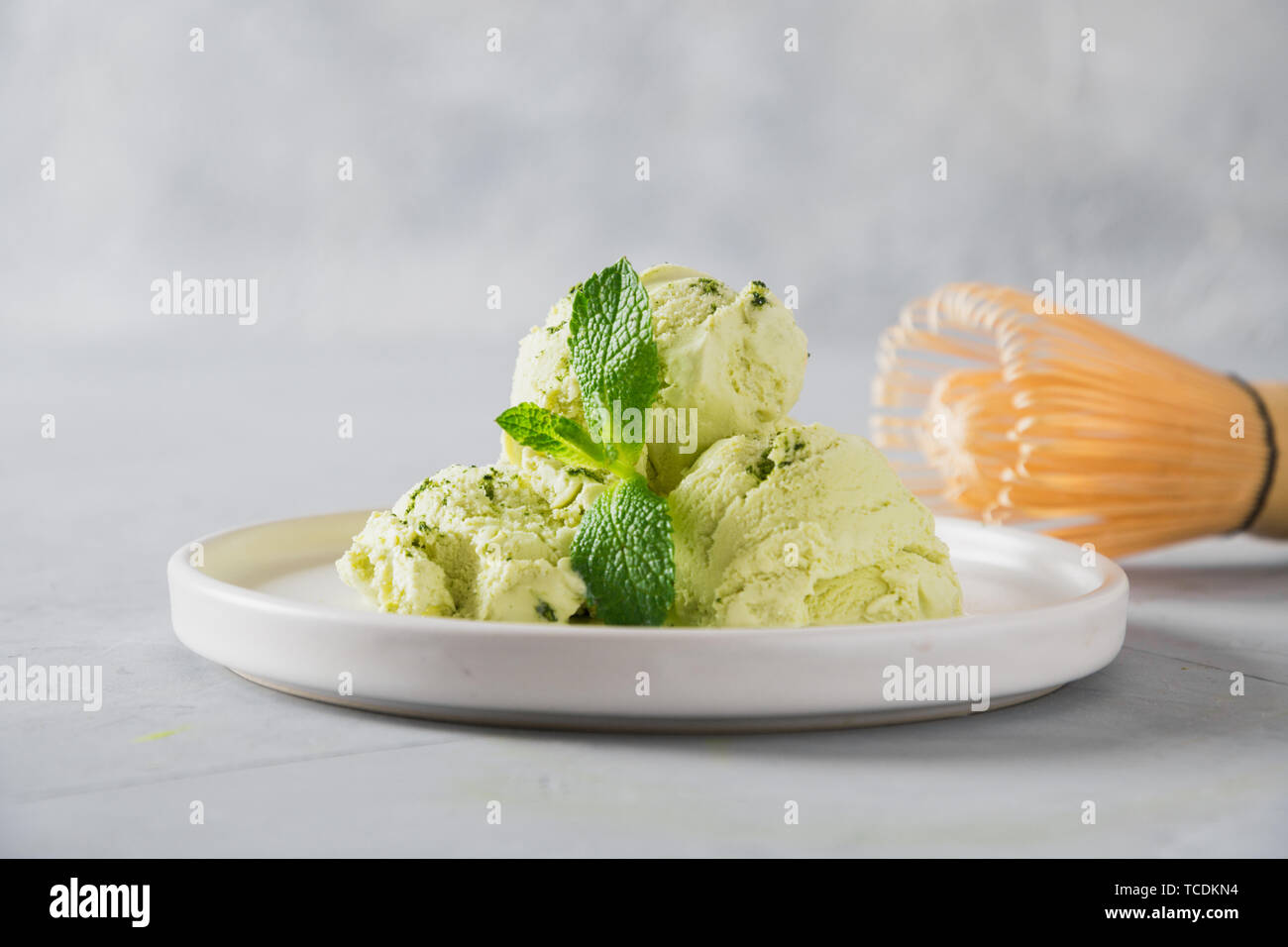 Green matcha ice cream and mint on grey table. Close up. Stock Photo