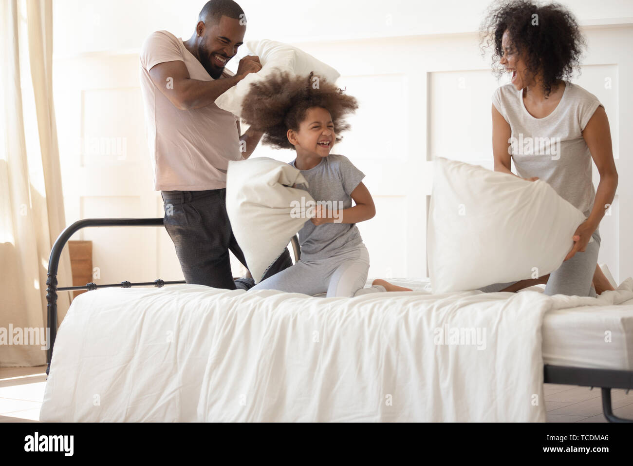 Carefree Black Parents Small Kid Enjoying Pillow Fight On