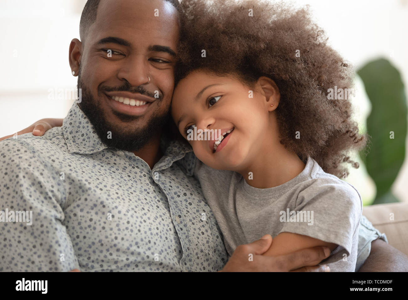 Small cute mixed race kid daughter embrace loving black dad Stock Photo