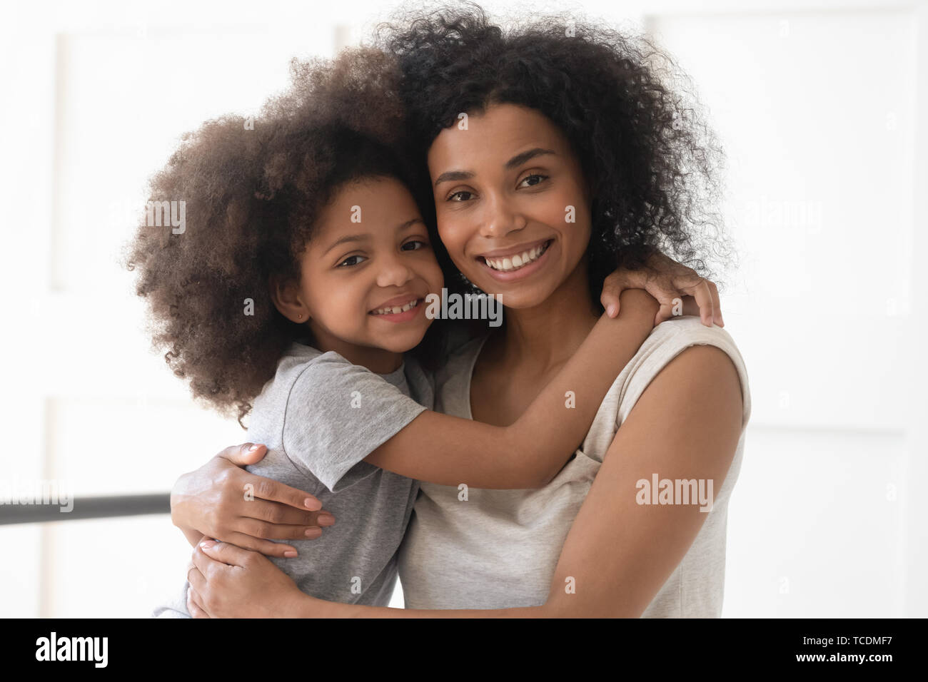 African single mother and child daughter embrace looking at camera Stock Photo