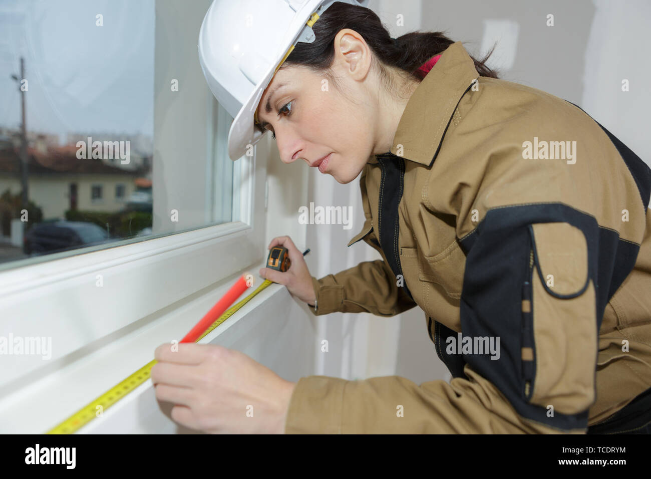 woman measuring window frame with tape measure Stock Photo - Alamy