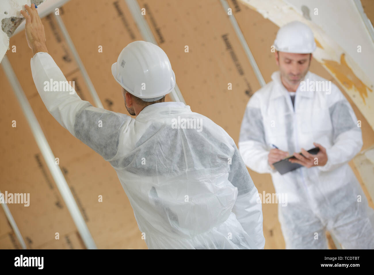workers plastering a wall using trowel Stock Photo