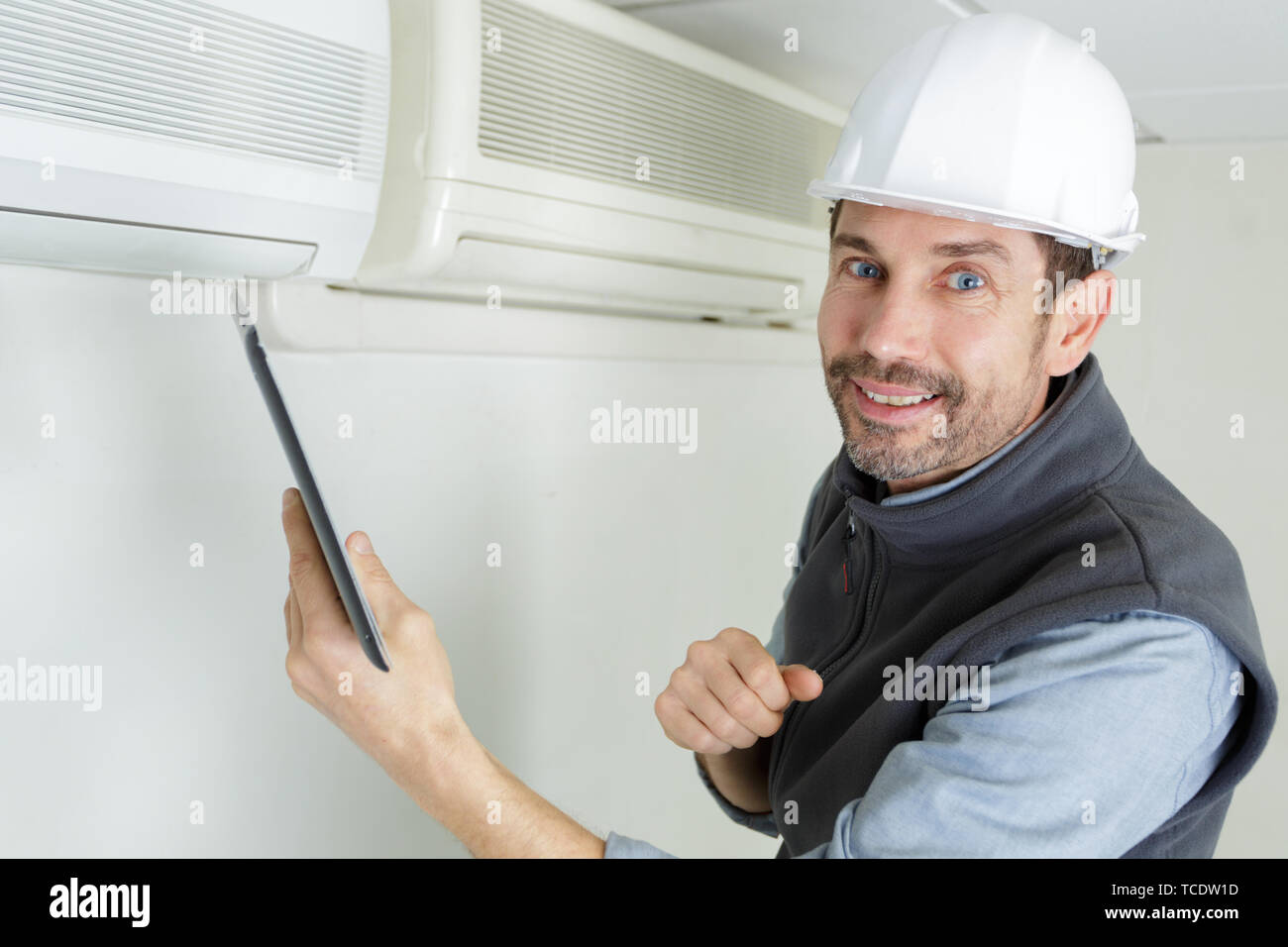 happy handyman repairing air conditioning system Stock Photo Alamy