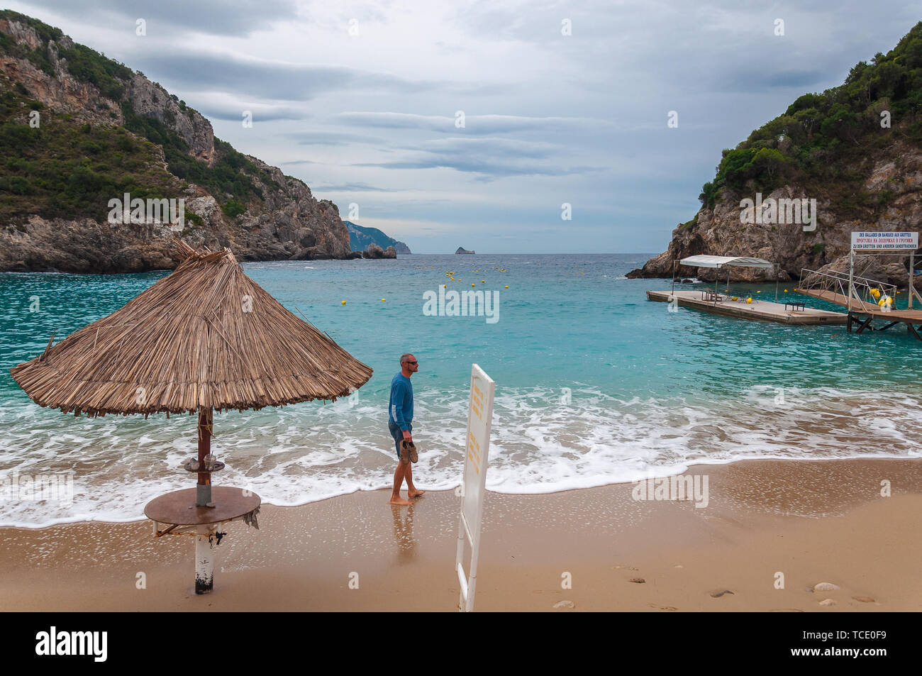 CORFU GREECE - OCTOBER 23 2018: Man on the Paleokastritsa bay beach with Kolyviri island background Stock Photo
