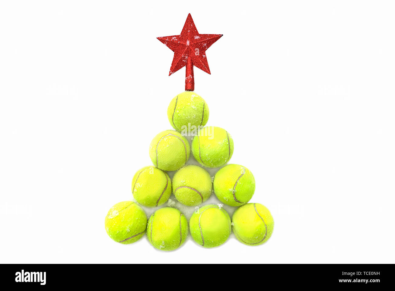 Red star on tennis ball on white snow background. Merry Christmas and New year concept with tennis balls. Stock Photo