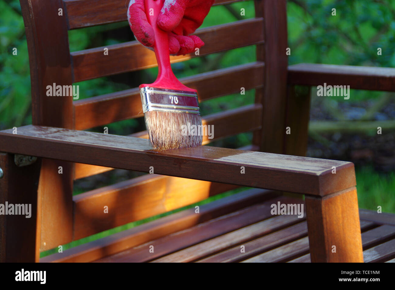 Garden furniture brush painting. Hand painting the wooden chair outdoor