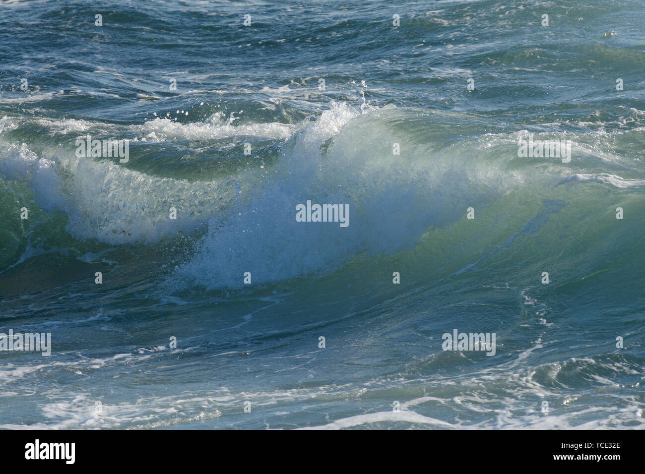 View of bright clear water of ocean in big wave curling in sunlight Stock Photo