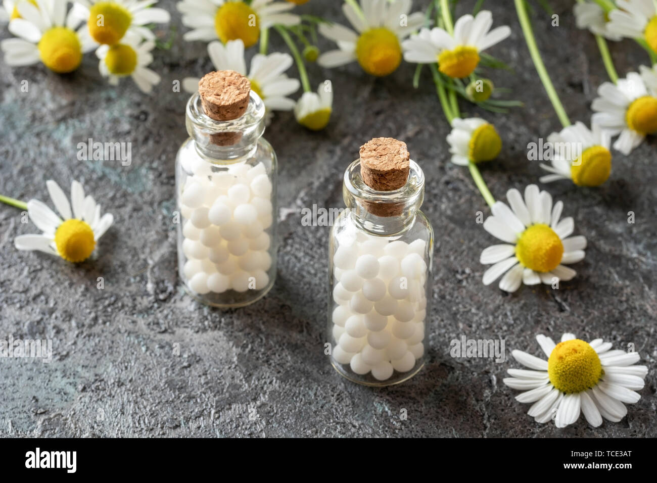 Bottles of homeopathic remedies with fresh chamomile flowers Stock