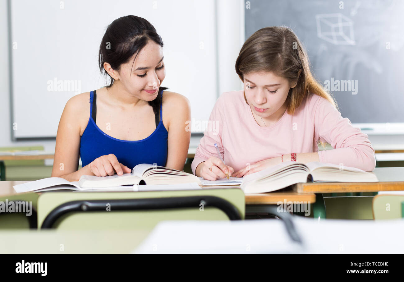 Smiling schoolgirls are learning at the desk in the class Stock Photo ...