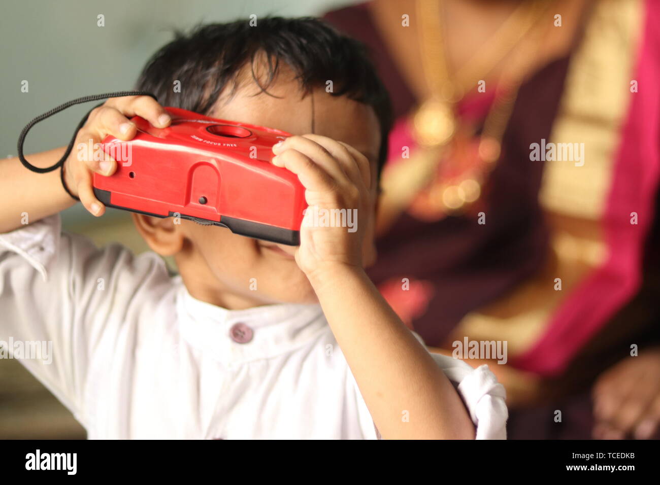 Maski, India 24 May,2019 : Little Indian kid trying to capture the photo using camera at home. Stock Photo