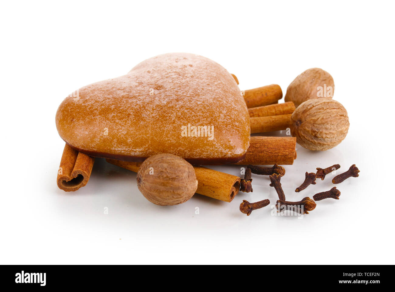 Heartshaped cookie with cinnamon, nutmegs and carnation isolated on