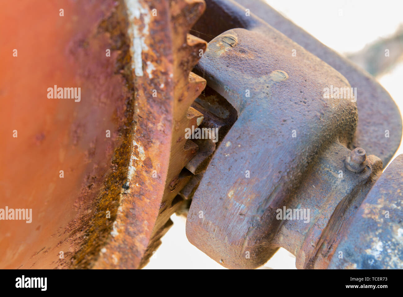 Close-up shot of aged metal gear wheel in red rusty flakes being ...