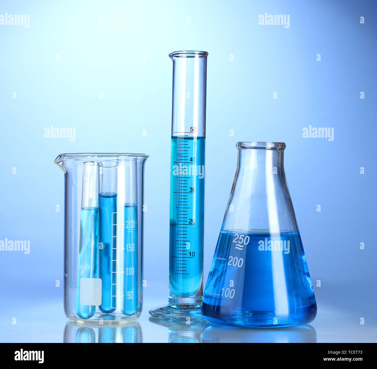 Laboratory glassware with blue liquid with reflection on blue ...