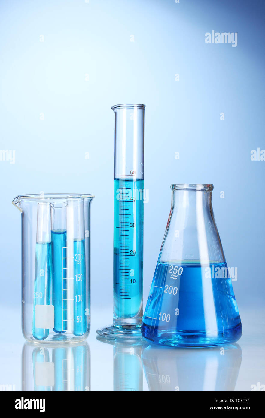 Laboratory glassware with blue liquid with reflection on blue ...