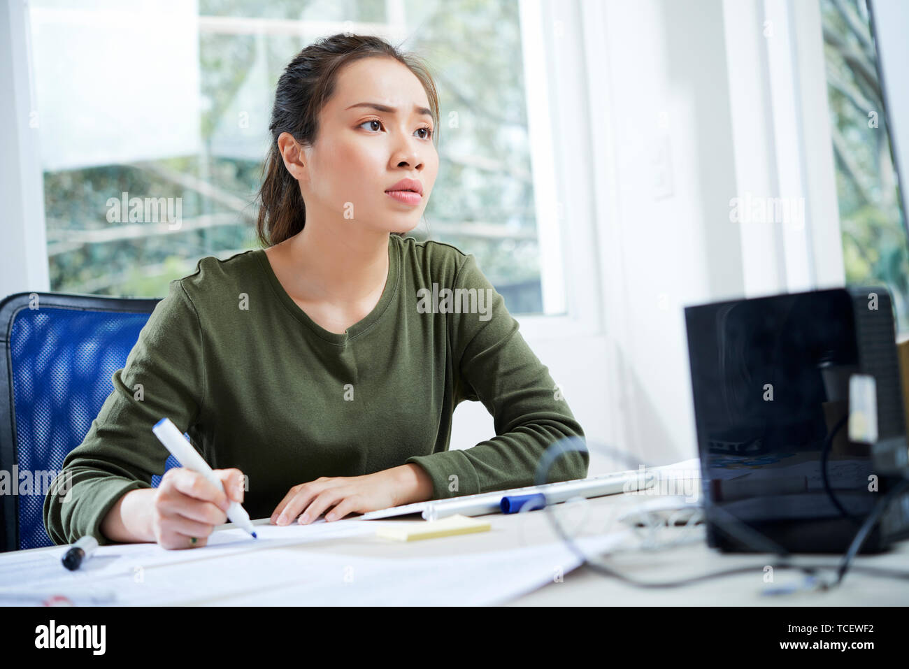 Young Vietnamese UI designer working on website interface at her office table Stock Photo