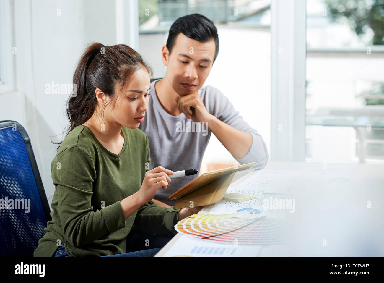 Team of UI designers discussing color scheme for new application for tablet computers Stock Photo