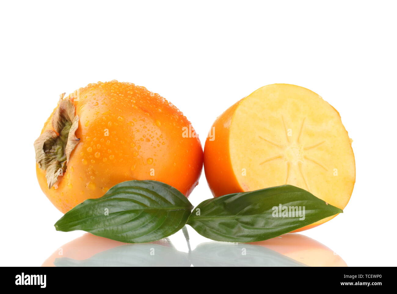 Appetizing persimmons with droplets and leaf isolated on white Stock Photo