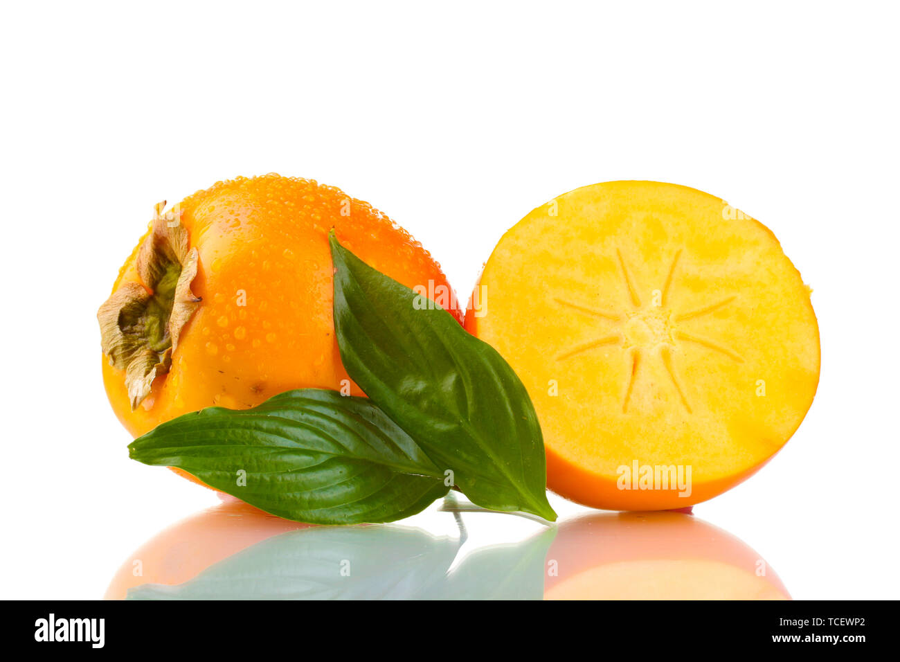 Appetizing persimmons with droplets and leaf isolated on white Stock Photo